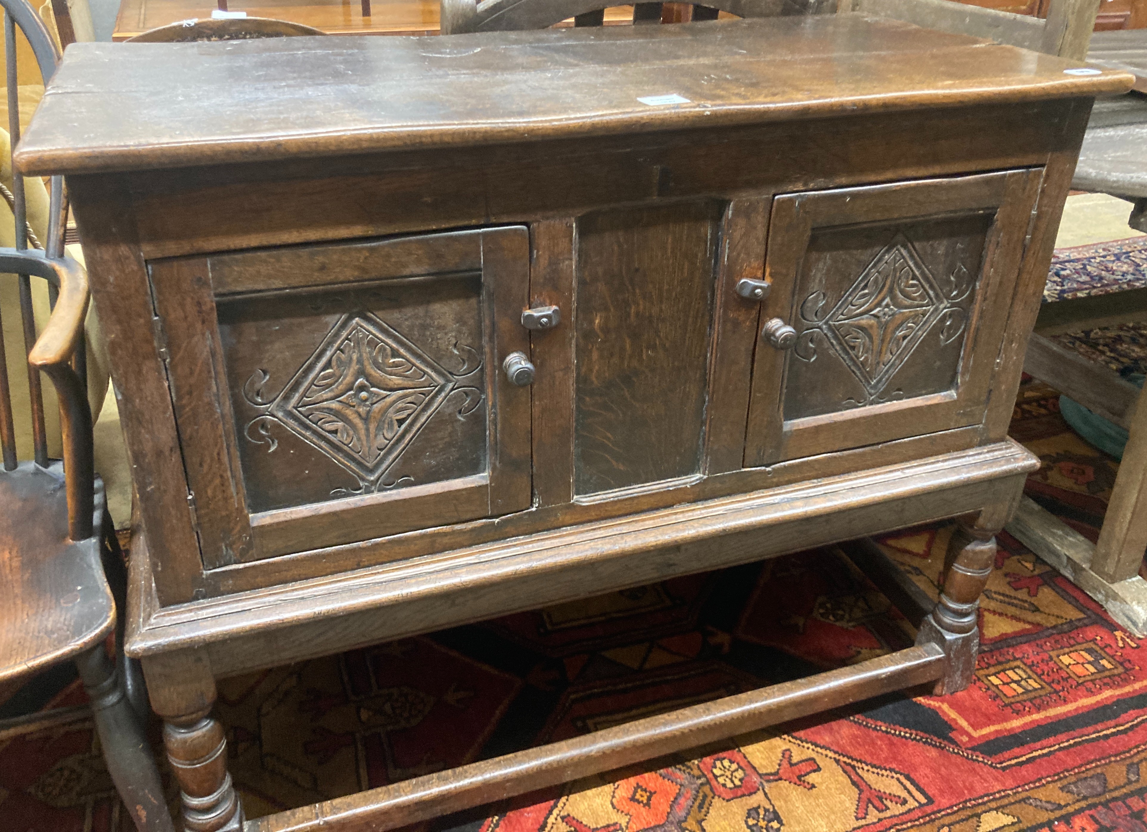 A Tudor style oak two door cupboard, enclosed by two doors, width 108cm, depth 50cm, height 88cm